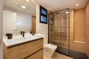 a bathroom with a toilet and a sink and a shower at Calle Larga 48 golf incluido in Jerez de la Frontera +23 photos