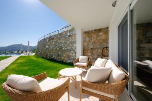 Un patio con sillas de mimbre y una mesa. en Seahorse Villa, en Limenas