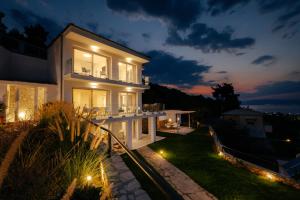 una gran casa blanca por la noche con luces en Seahorse Villa, en Limenas