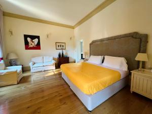a bedroom with a large bed and a chair at Hotel Villa Casanova in Lucca