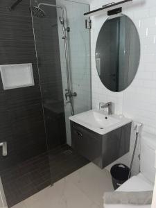 a bathroom with a shower and a sink and a mirror at Résidence Cap Sud Ngor Almadies in Dakar +6 photos