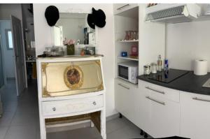 a white kitchen with a counter and a counter top at CARCASSONNE Studio avec Jacuzzi y piscina in Carcassonne
