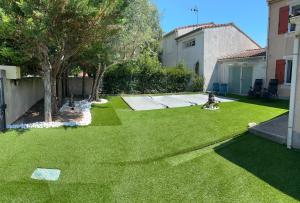 a child sitting in the yard of a backyard at CARCASSONNE Studio avec Jacuzzi y piscina in Carcassonne