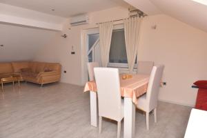 a dining room with a table and chairs and a couch at Apartman Terasa in Bijeljina