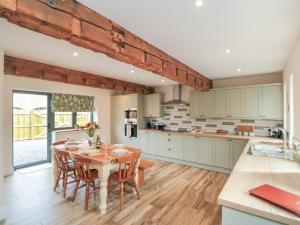 a kitchen with a wooden table and chairs in a room at The Hay Barn in Thirsk