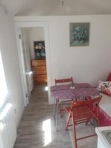 a room with a table and a couch and a table and chairs at Kays Cottage in Galway