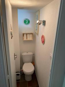 a small bathroom with a toilet and a green clock at Studio terrasse plein sud avec coin montagne in Saint-Chaffrey