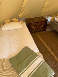 a bed in a tent with a nightstand and a bed sidx sidx sidx sidx at Tranan glamping in Svanhult