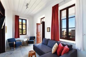 Palatakia - Adults Only في كاتو درياس: غرفة معيشة مع أريكة زرقاء وستائر حمراء