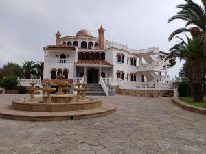 a large white house with a fountain in front of it at Villa Cabo in Martil