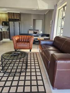 ein Wohnzimmer mit einem Ledersofa und einem Tisch in der Unterkunft Grey Net in Palatswe
