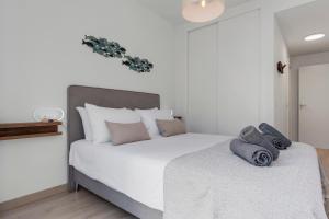 a bedroom with a large white bed with two pillows at Casa Los Vecinos - Luxury Rooftop Penthouse in Estepona +28 photos