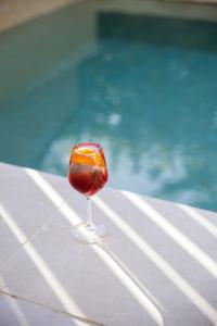 a wine glass sitting on a table next to a swimming pool at Azur Hotel in Athens