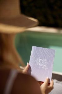 a woman holding a piece of paper with writing on it at Azur Hotel in Athens