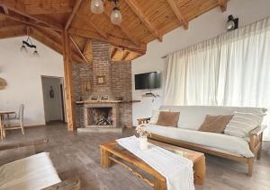 ein Wohnzimmer mit Couch und Kamin in der Unterkunft Chacra María Ramona in Las Golondrinas