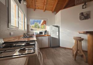 eine Küche mit Herd und Kühlschrank in der Unterkunft Chacra María Ramona in Las Golondrinas
