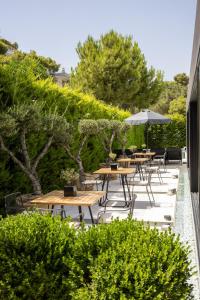 a row of tables and chairs with an umbrella at Azur Hotel in Athens