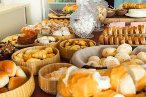 a table with many different types of breads and pastries at Pousada Viver Capitólio in Capitólio