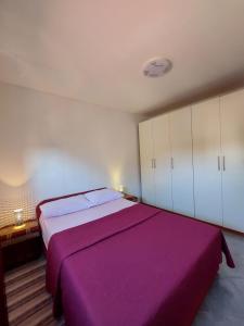 a bedroom with a large bed with a purple blanket at Tina in Kolan