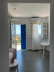 a bedroom with a blue door and a table and a bed at Thea Vouno Studios in Agia Pelagia