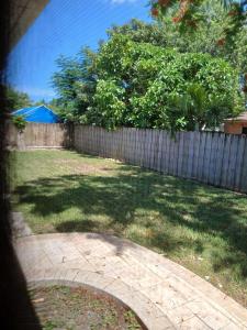 a backyard with a fence and a yard with trees at Beautiful Miami Home in Miami