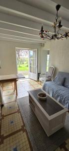 a living room with a couch and a table at Ferme rénovée tout confort en pleine campagne in Larbey