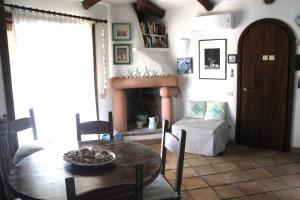 a dining room with a table and a fireplace at Sea View Eden in Porto Cervo