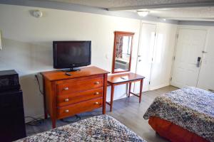 a bedroom with a dresser with a television on it at Rodeway Inn Auburn Hills - Detroit in Auburn Hills