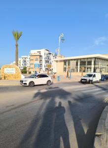 a shadow of a person walking down a street at Appartement a Martil in Martil