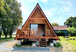 a tiny house with a deck and a porch at Le Chalet dans les Près in Les Pégués
