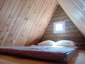 a bed in a room with a wooden ceiling at Le Chalet dans les Près in Les Pégués