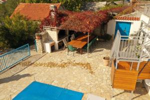 a patio with a table and chairs and a house at Skradin villa et studio in Dubravice