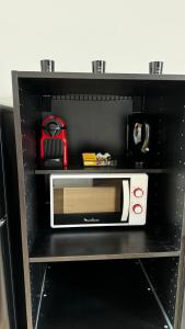 a microwave sitting on a shelf in a kitchen at Maison Cosy - Maison de Maitre in Saint-André