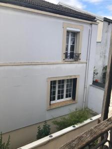 a white building with a window and a balcony at Chambre de 9m2 in Bagnolet