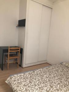 a bedroom with a bed and a desk and a chair at Chambre de 9m2 in Bagnolet