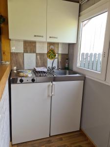 a small kitchen with a sink and a stove at Kleine Ferienwohnung in der Natur in Rheinsberg +14 photos