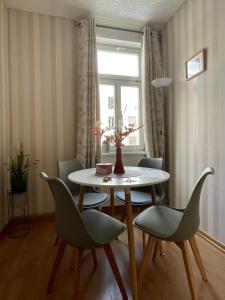 ワイマールにあるFerienapartment Weimar Altstadt 1のテーブルと椅子と窓のあるダイニングルーム