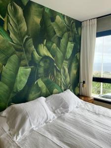 a bedroom with a bed with a mural of leaves at Casa Las Plataneras in Santa Maria de Guia de Gran Canaria