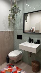 a bathroom with a sink and a toilet and a mirror at AS Pavan Saarlouis Ferienwohnung in Saarlouis