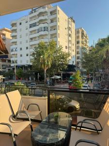 a balcony with a table and chairs and a building at Villa La Mer Durres in Durrës