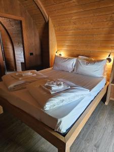 a large bed in a room with a wooden wall at Vicolungo Glamour Lodge & SPA - Free SPA Hot Tub e Sauna in Vicolungo +33 photos