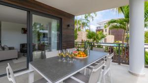 un tavolo con bicchieri da vino e un cesto di frutta sul balcone di Luxe Breeze a Blue Bay