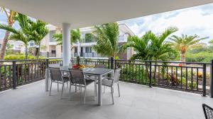 balcone con tavolo, sedie e palme di Luxe Breeze a Blue Bay