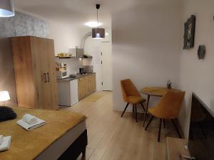a kitchen with a table and chairs in a room at Apartman Liliom in Subotica