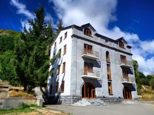 a large white building with a tree in front of it at Jermuk Villa Imperial in Jermuk