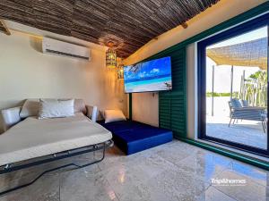 Una televisión o centro de entretenimiento en Casa Serendity Beautiful 4Br 4Ba home one block from Malecon