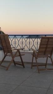 a pair of chairs sitting on a balcony overlooking the ocean at Emerald Blue in Skiathos Town