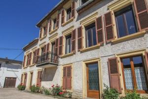 a building with brown shuttered windows and a balcony at Villa Alba avec piscine et Spa in Metz