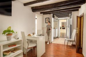 a woman standing in a kitchen with a table and chairs at The Right Place 4U Monserrato Apartment in Rome