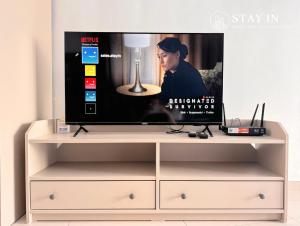 a tv on top of a white entertainment center at Pinnacle PJ - Free Parking, LRT, WiFi, Netflix in Petaling Jaya
